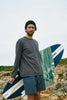 Man wearing Rhythm Longsleeve Tshirt while holding a surfboard