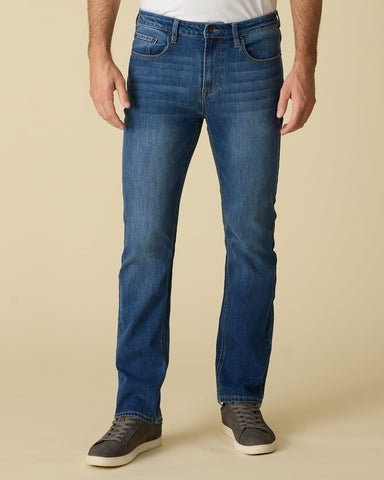 Blue jeans worn by a person on a beige background
